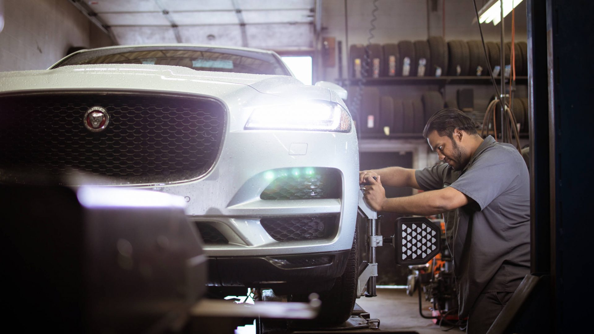 MTC Tire Oakville technician performing computerized wheel alignment on a Jaguar F-Pace