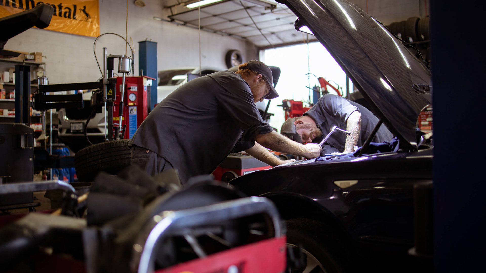 MTC Tire Oakville mechanics performing automotive repairs under a vehicle hood